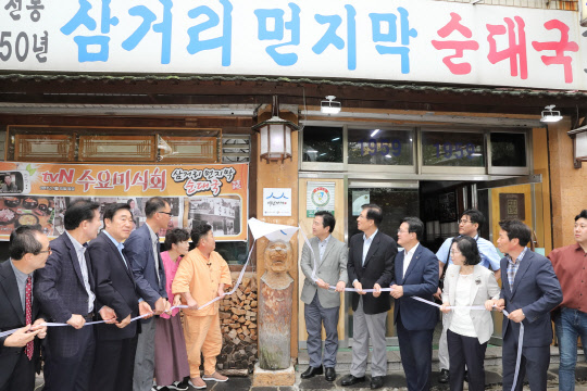 21일 홍종학 중기부 장관(왼쪽 일곱번째)이 백년가게 1호점으로 선정된 서울 영등포구 '삼거리먼지막순대국'에서 현판식을 하고 있다. 중기부 제공